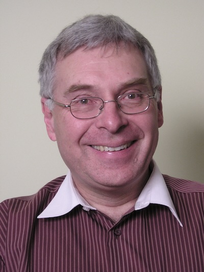 A headshot of Peter Hall smiling warmly