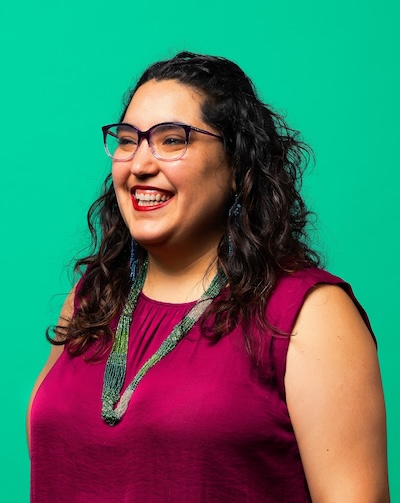 Gala Camacho Ferrari, smiling, on a vibrant green background